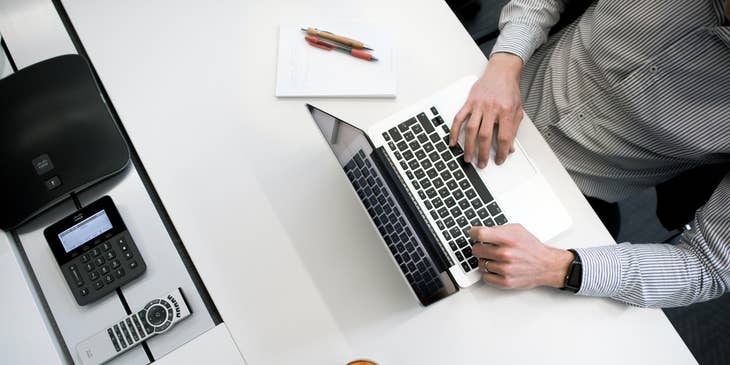 Proposal writer typing on his laptop to finish the documents needed during the pitch