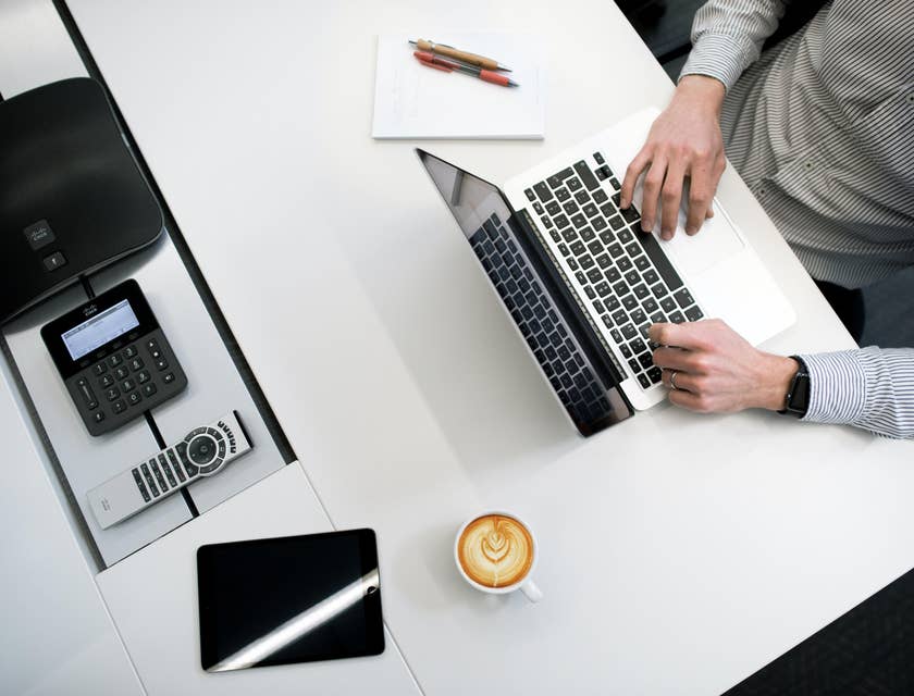 Proposal writer typing on his laptop to finish the documents needed during the pitch
