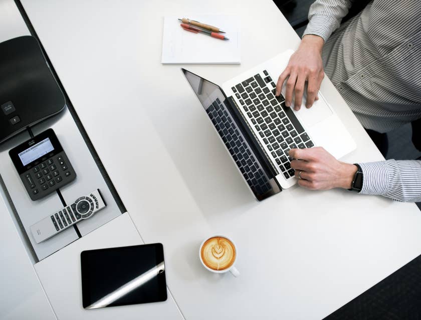Proposal Writer typing on his laptop to finish the documents needed during the pitch