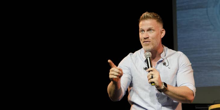 Public speaker interacts with the audience as he discusses a new company and its product