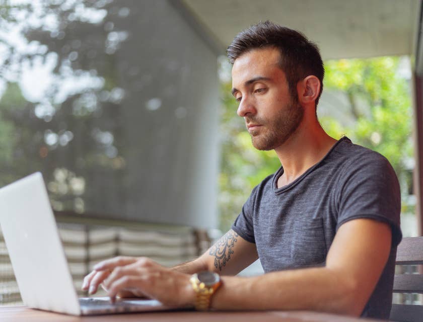 male Python developer looking at the screen of his laptop while sitting