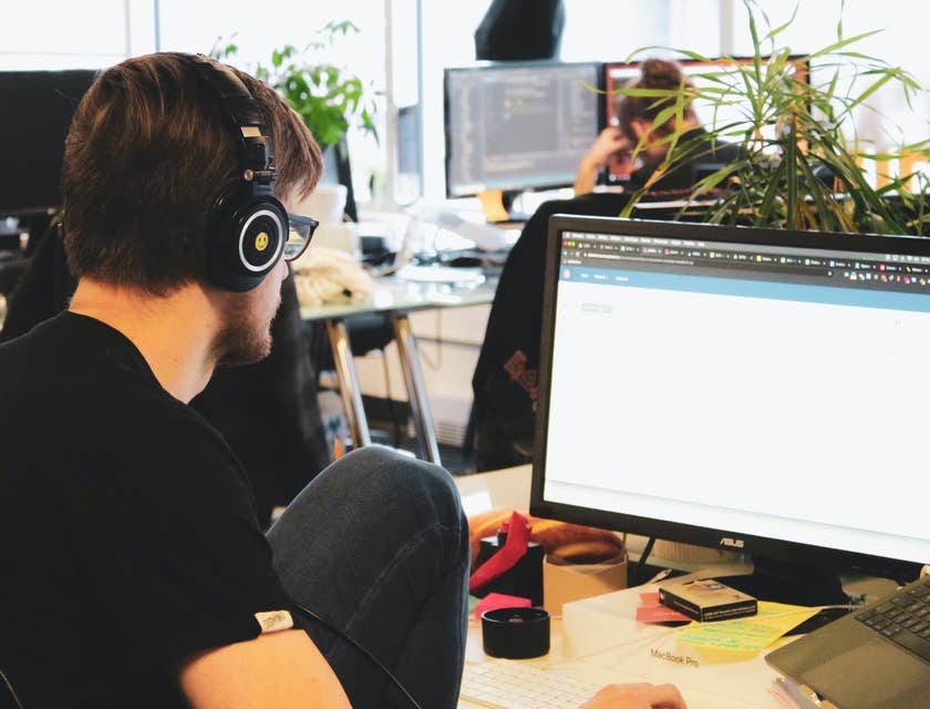 QA Automation Engineer wearing a headset and working on test designs at his workstation