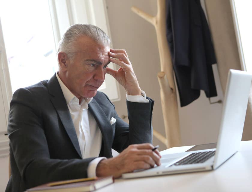 A real estate lawyer drafting some legal documents on his laptop for a client's property.