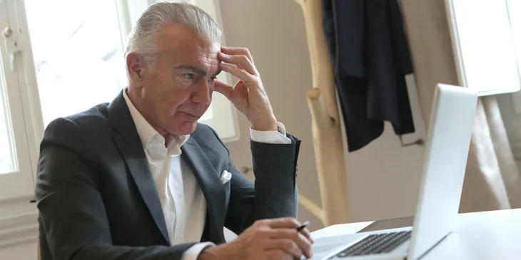 A real estate lawyer drafting some legal documents on his laptop for a client's property.