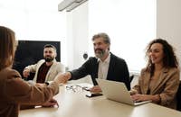 Three colleagues welcoming a new recruit to their team.