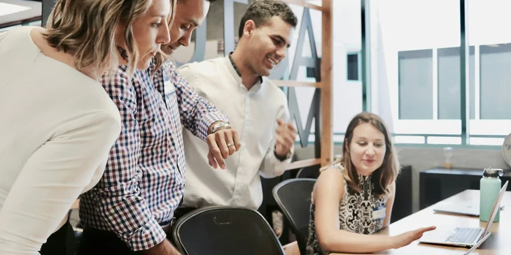 A female recruitment coordinator having a meeting with her coworkers.