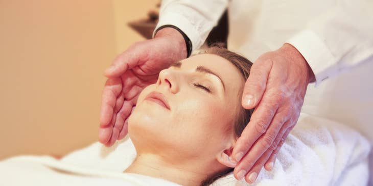A Reiki healer in a quiet room performing distance healing on a client.