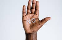 Mão com a palavra "não" escrita.