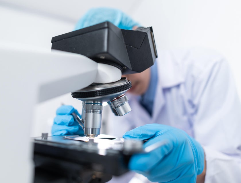 R&D engineer putting specimen on a microscope for research purposes
