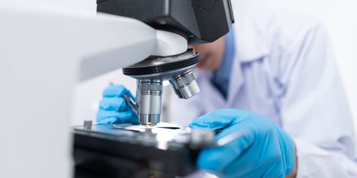 R&D Engineer putting specimen on a microscope for research purposes