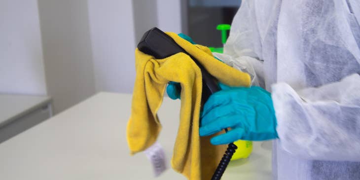 Residential cleaner wiping down a house phone