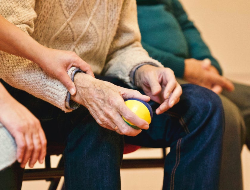 Residential counselor holding the hand of one of the residents while sitting on a bench