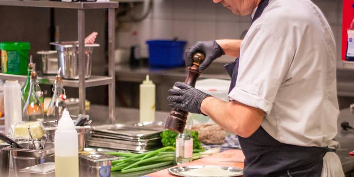 A Restaurant Cook in a restaurant kitchen setting preparing some ingredients for cooking.