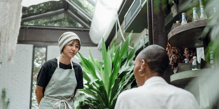 A Female Restaurant Manager talking to a staff member.