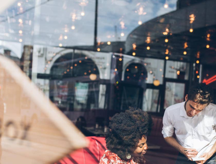 A Restaurant Server taking a customers order.