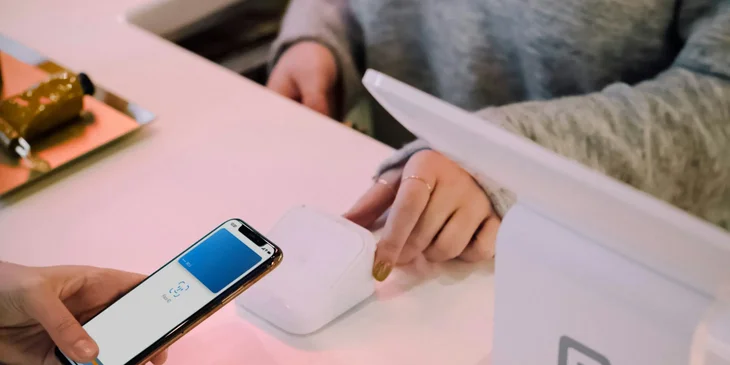 A retail associate processing a client's digital payment.