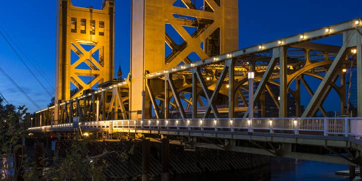 The tower bridge of Sacramento, California against the night sky.