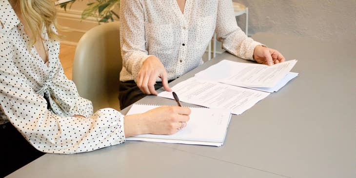 Un empleador y un empleado revisan una carta de reducción salarial.