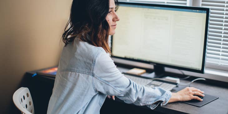 female sales applications engineer answering client inquiries while sitting in front of her workstation