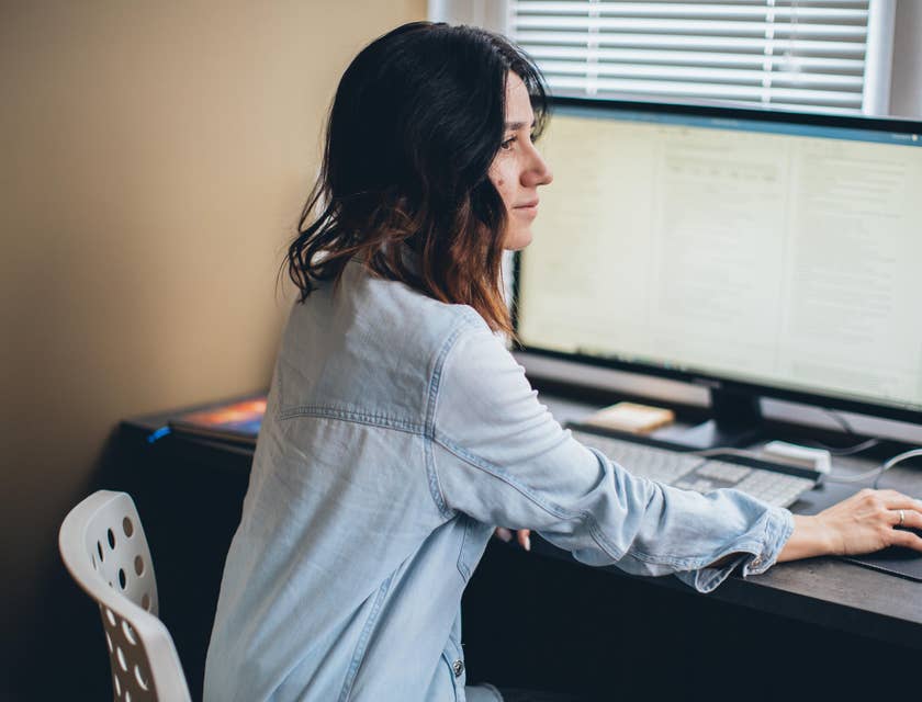 female sales applications engineer answering client inquiries while sitting in front of her workstation