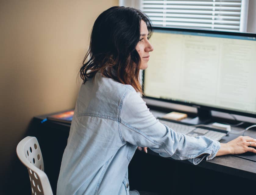 female Sales Applications Engineer answering client inquiries while sitting in front of her workstation
