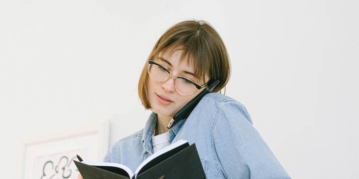 A female sales recruiter holding a planner while talking on the phone.