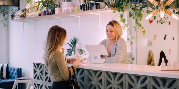 Salon receptionist issuing the receipt for the services as well as the product she bought.