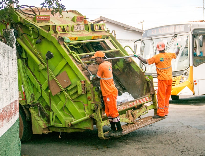 sanitation workers onboard a garbage collection truck