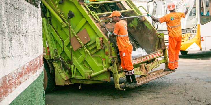 sanitation workers onboard a garbage collection truck
