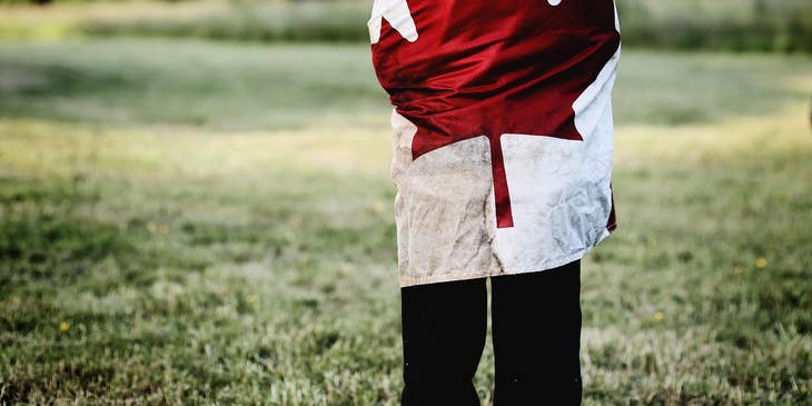 A Canadian child wearing a robe with a Canadian flag.