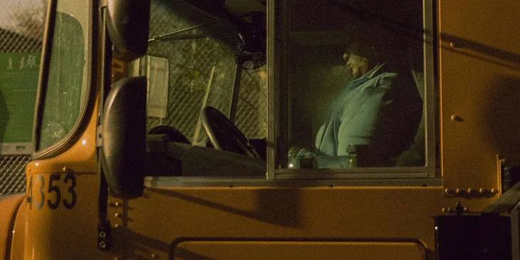 A school bus driver waits for students on a bus.