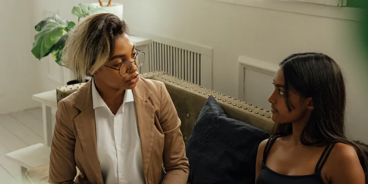 A school counselor listens to a student dealing with personal issues in a private room.