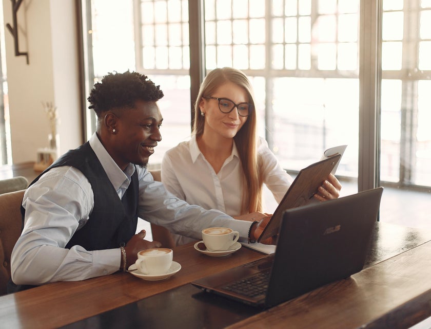 Senior accountant reviews a budget report while asking questions about payroll information