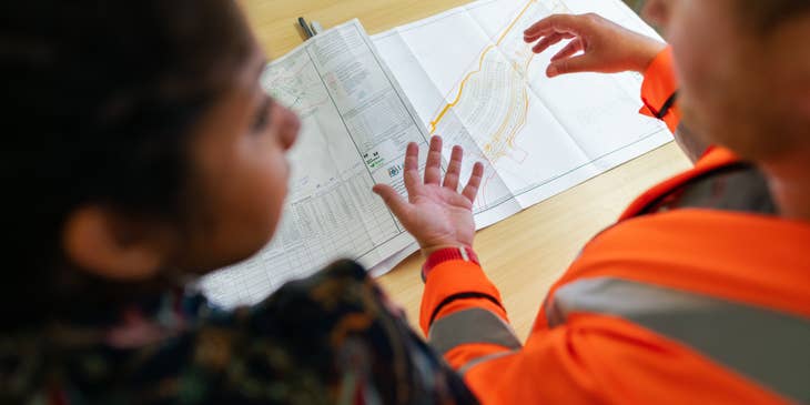 female senior civil engineer discussing with her colleague the expanse of the project