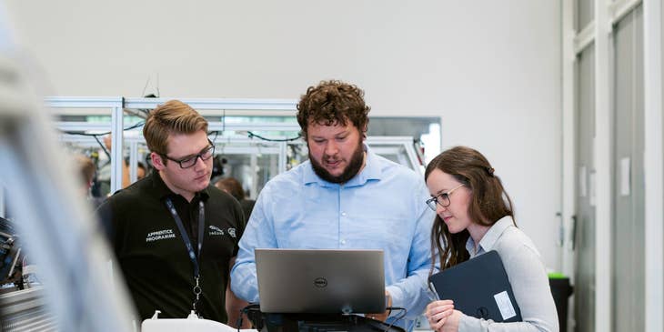 Senior DevOps engineer together with the software developers debugging the code of a program and looking for vulnerabilities before the official deployment