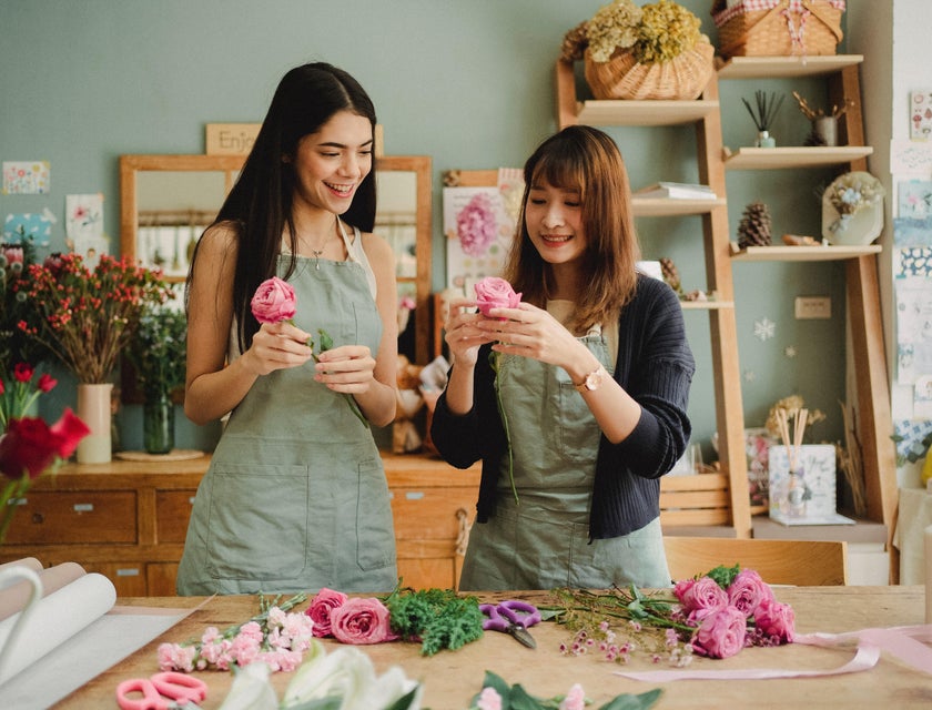 Shift leader training the new employee on floral arrangement