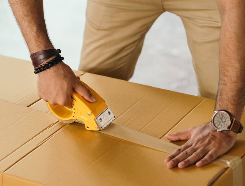 Shipping clerk packing the items in the box before forwarding it to the shipping department