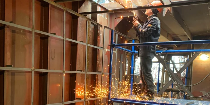 A skilled laborer working in an industrial building.