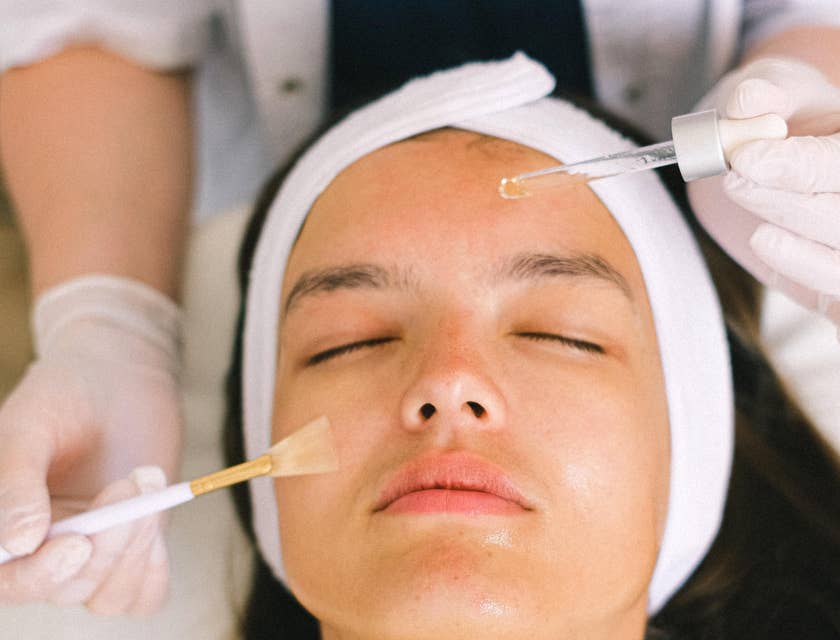 Skincare specialist applying skin products to a patient's skin.