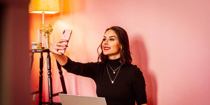 a social media influencer taking a selfie to promote beauty products on her social platform