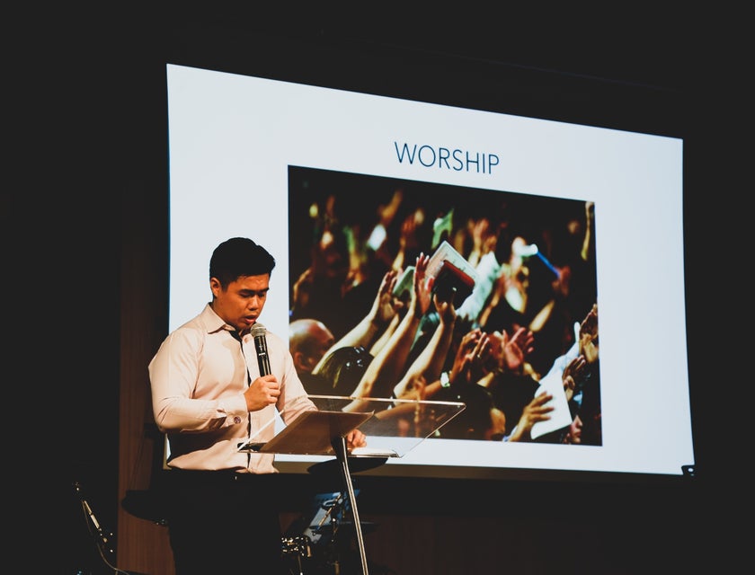 Social studies teacher discussing religion to his students on a podium