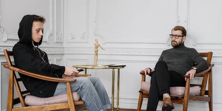 Social Worker looking at a client wearing a black hooded sweater