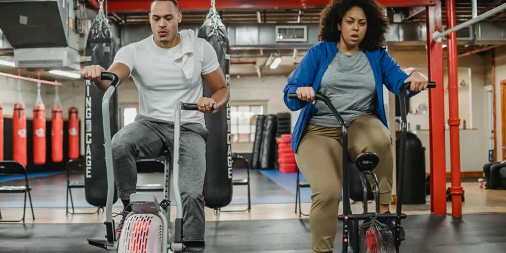 A women in a spin class being taught by an instructor.