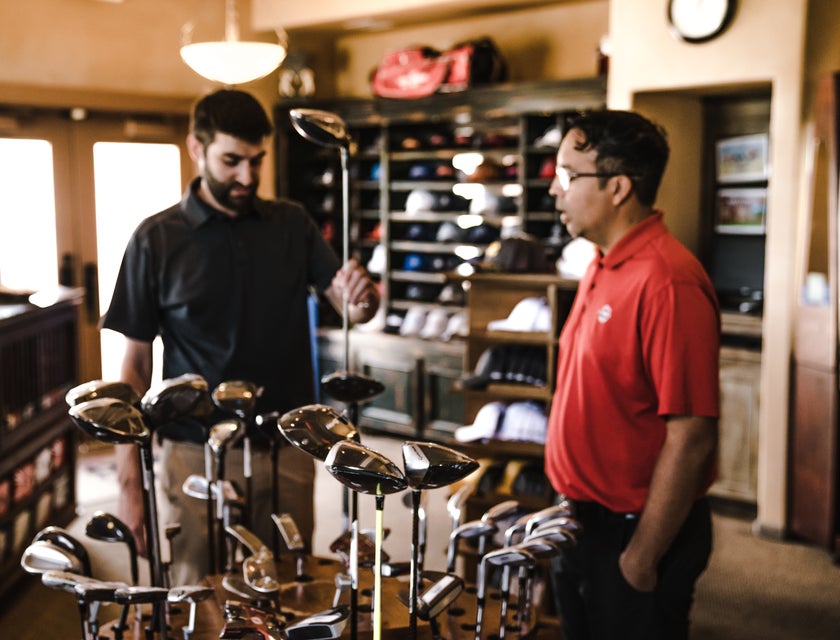 Sports Administrator checking out new golf clubs to purchased for the club