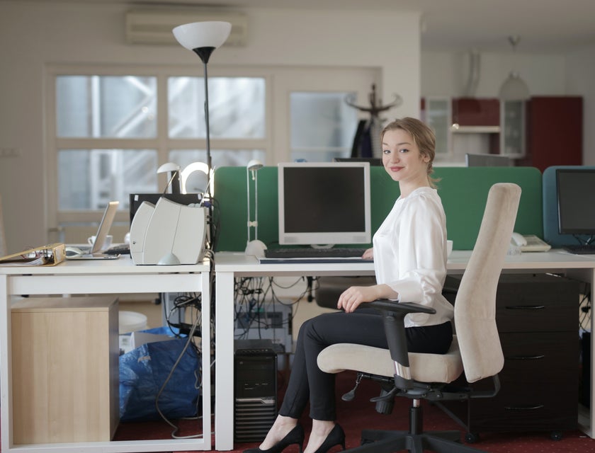 female staff assistant sitting on her workstation and getting ready to start her day at the office
