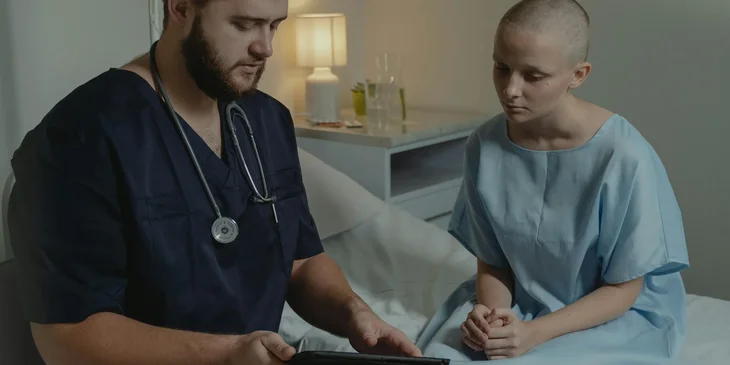 A staff nurse explains to a patient the treatment plans and medications as directed by a doctor.