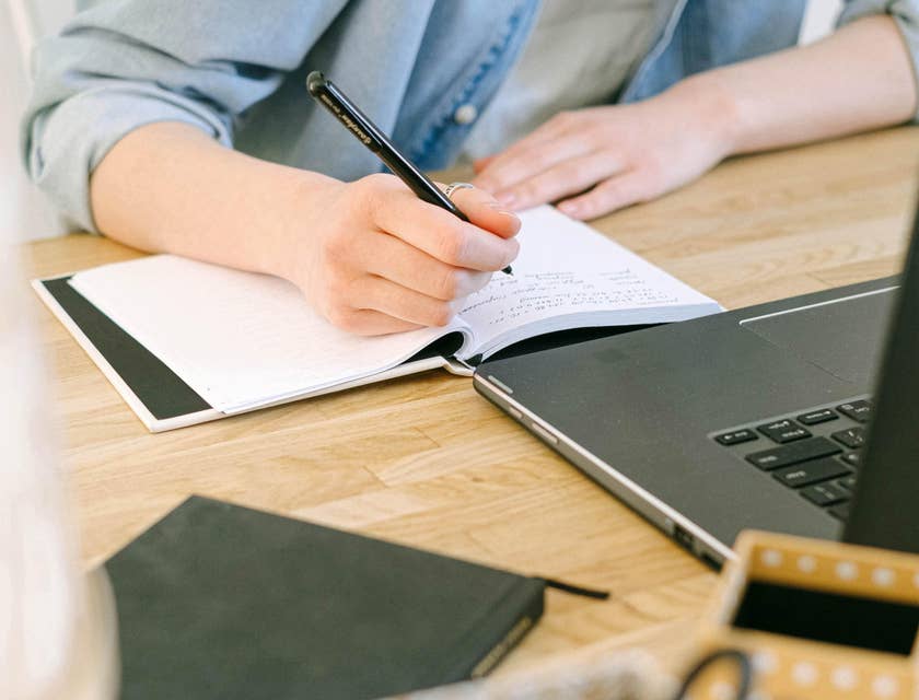 A staffing coordinator writing on a notebook.