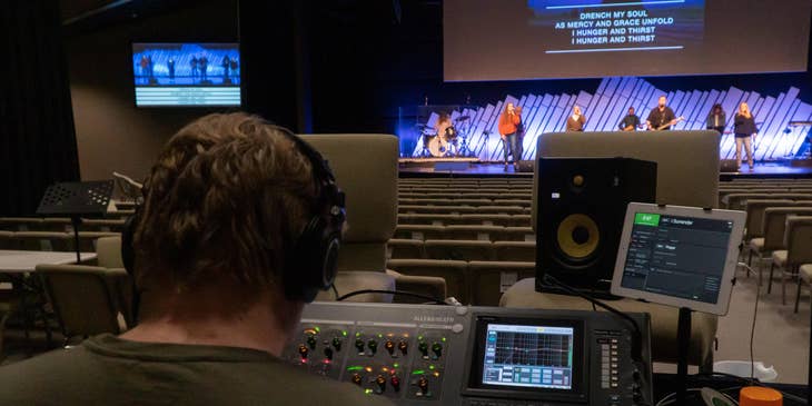 a band of musicians playing on stage supervised by a Stage Manager