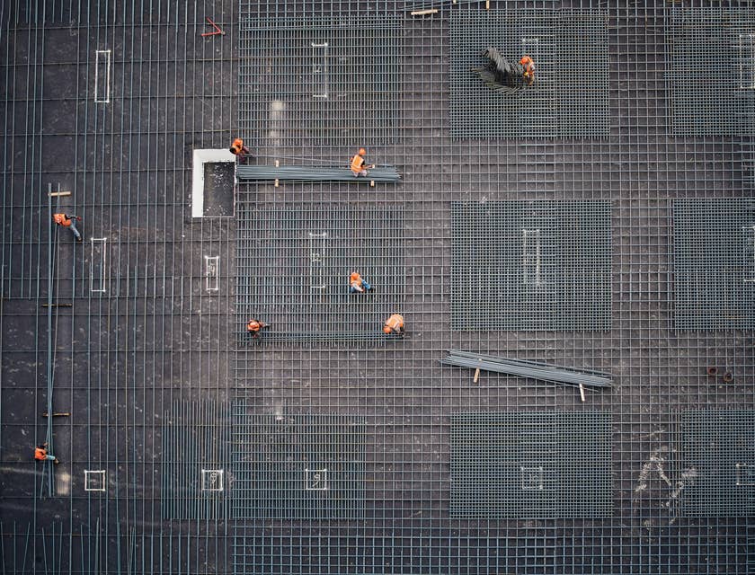 Steel fixers positioning steel bars on construction site.