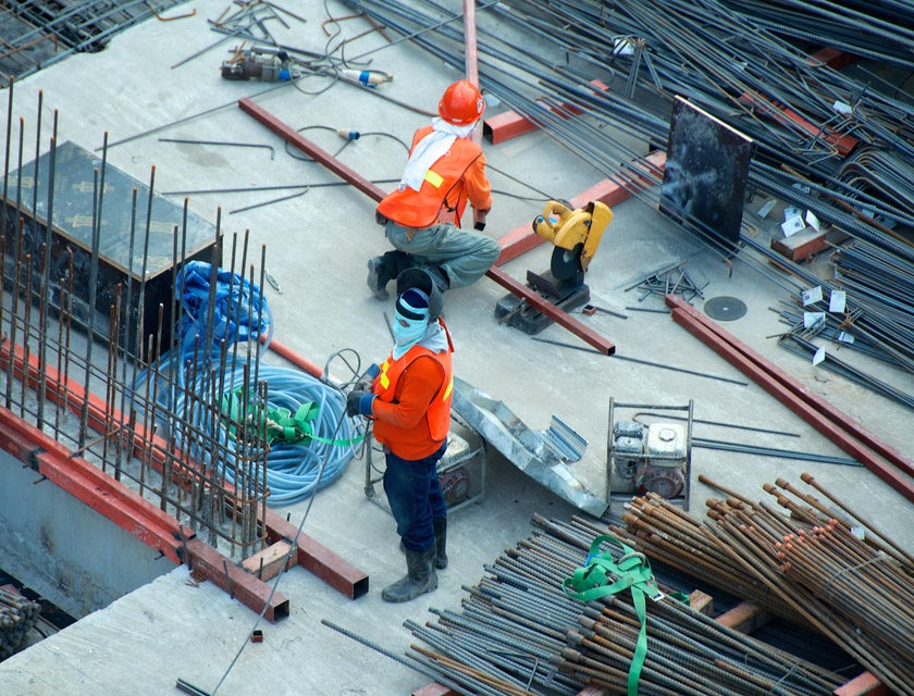 Steel workers installing steel bars on a building site.